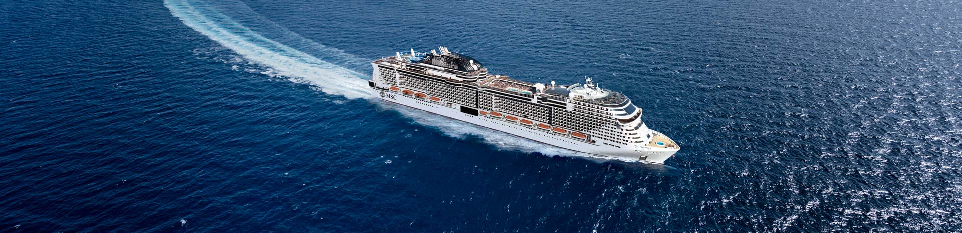 A modern cruise ship navigating through deep blue waters | MSC Cruises A modern cruise ship navigating through deep blue waters | MSC Cruises