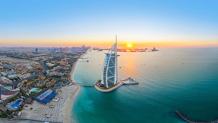 Dubai's Burj Al Arab with a stunning sunset over the Arabian Gulf | MSC Cruises