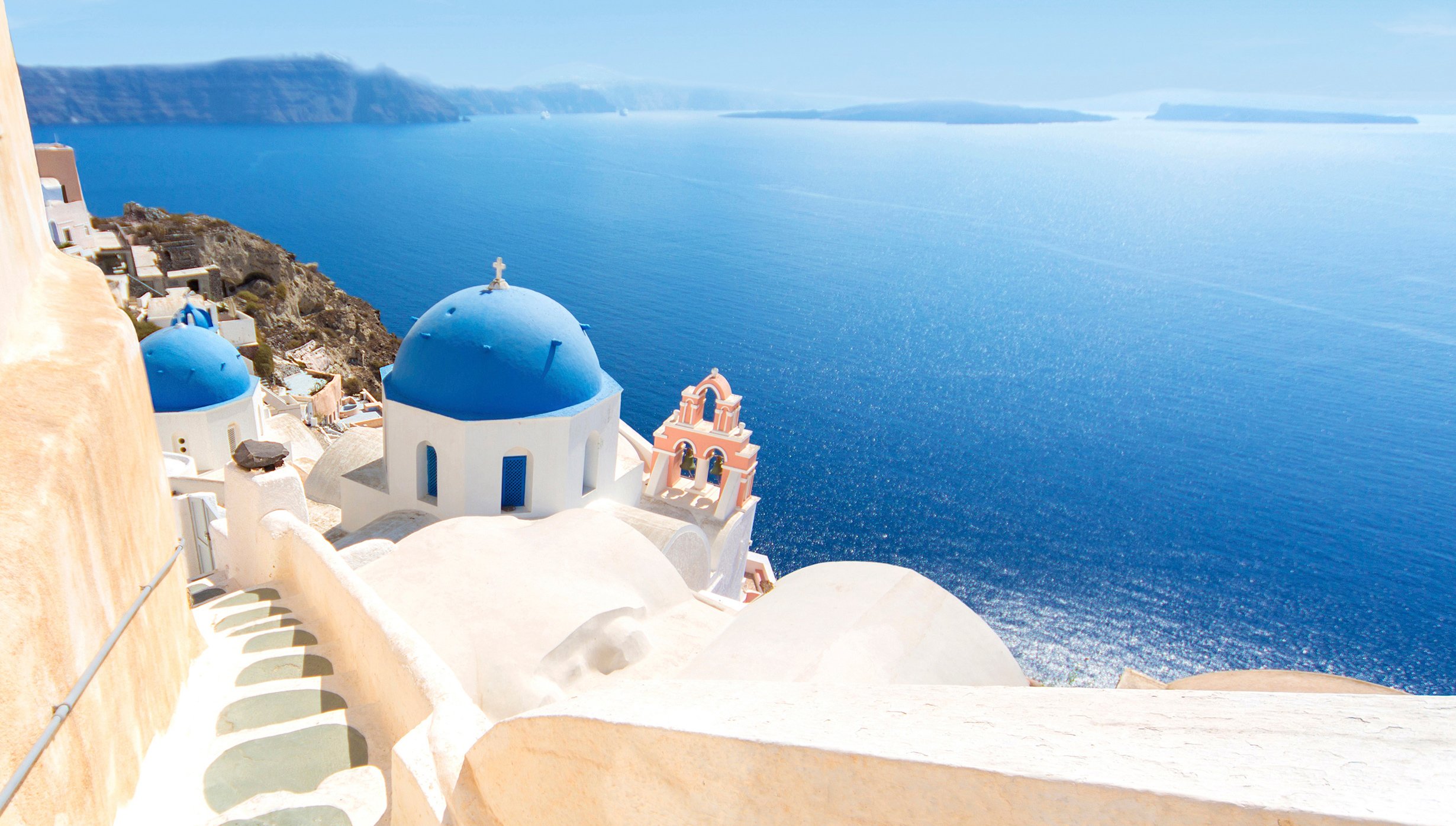 Iconic blue-domed churches overlooking the Aegean Sea in Santorini | MSC Cruises