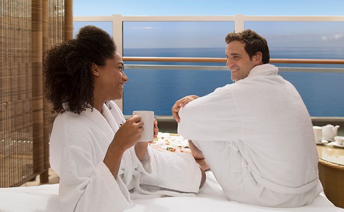 Couple in bathrobes enjoying coffee on a private balcony with ocean views | MSC Cruises Couple in bathrobes enjoying coffee on a private balcony with ocean views | MSC Cruises